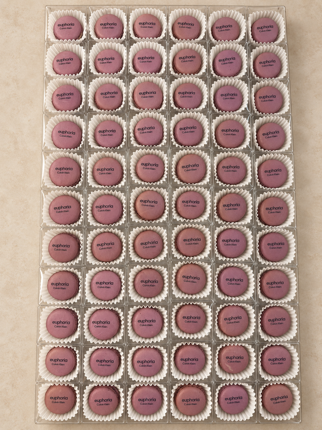 Purple macarons printed with the Calvin Klein euphoria logo in individual clear boxes