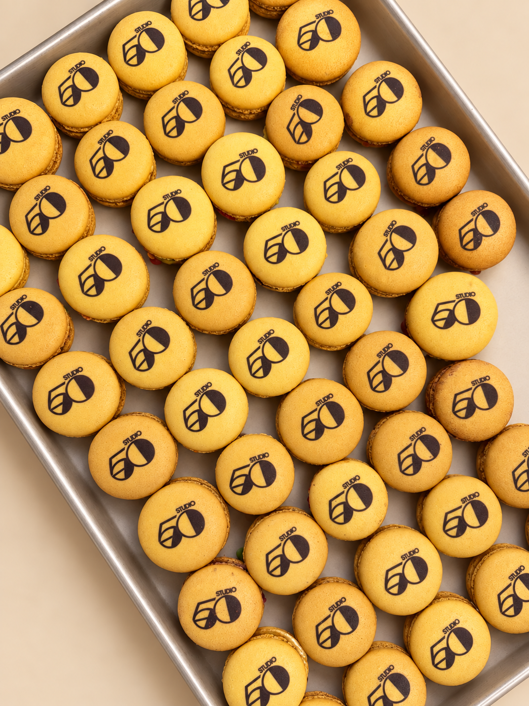 Rows of yellow macarons printed with the Studio 50 logo