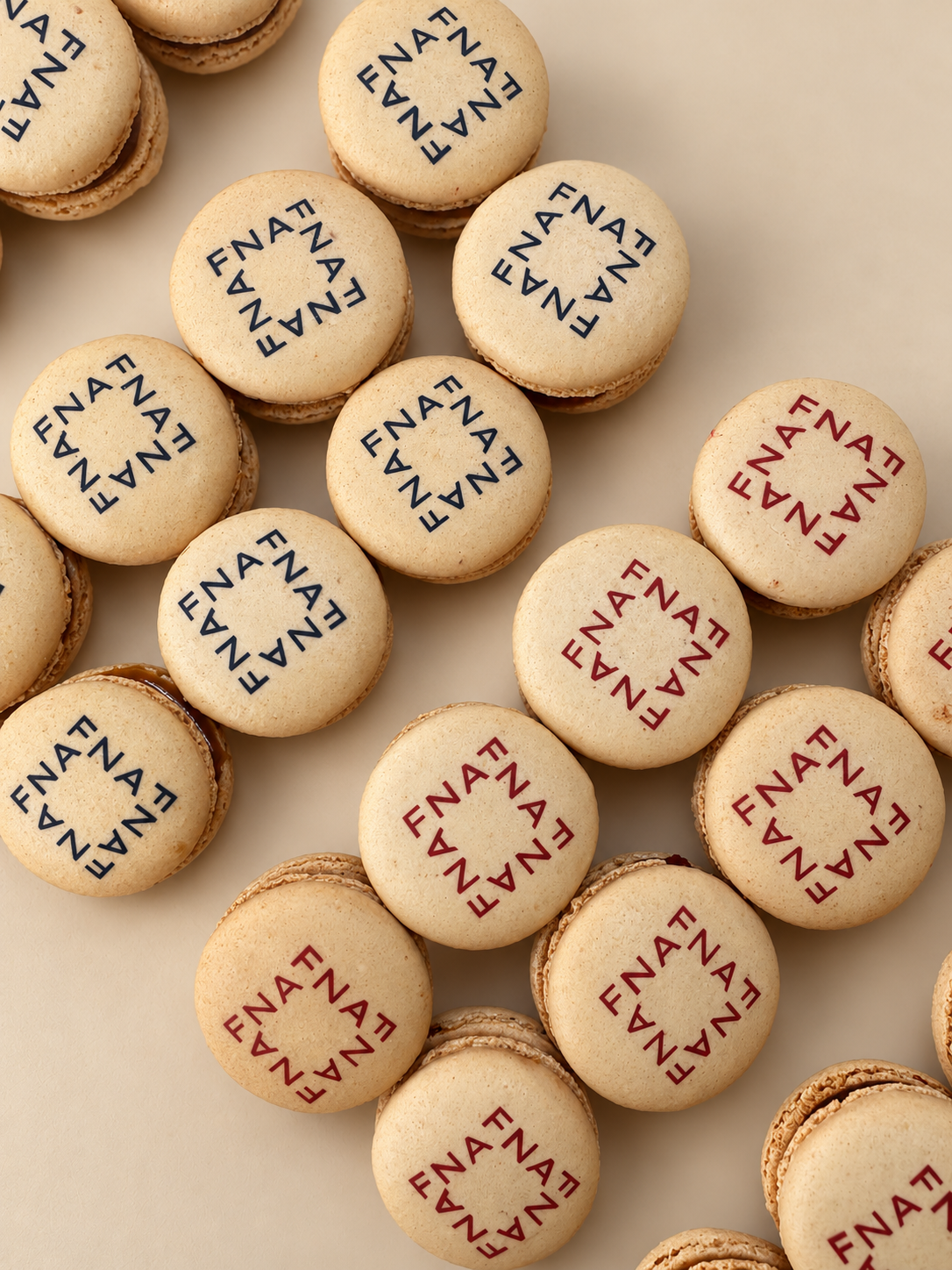 Ivory macarons printed with square FNAF lettering in navy and red