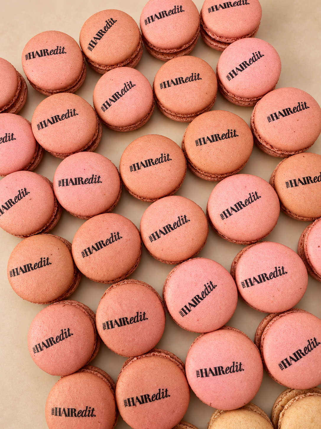 Pink French macarons printed with The Hair Edit logo in black