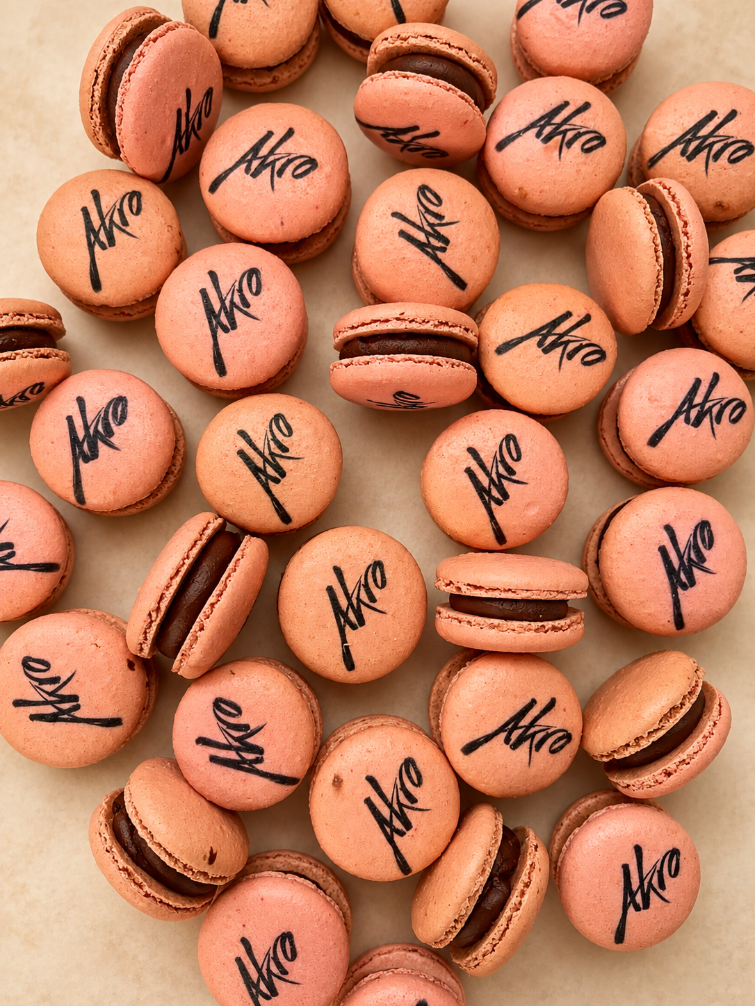 Pink French macarons printed with the Akro script logo