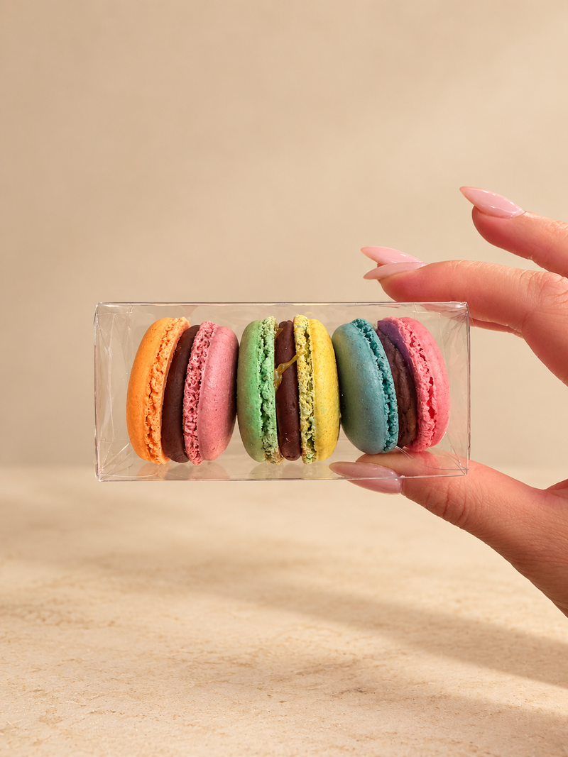 Clear box of three two-tone Old Navy x Christopher John Rogers macarons in a set color order